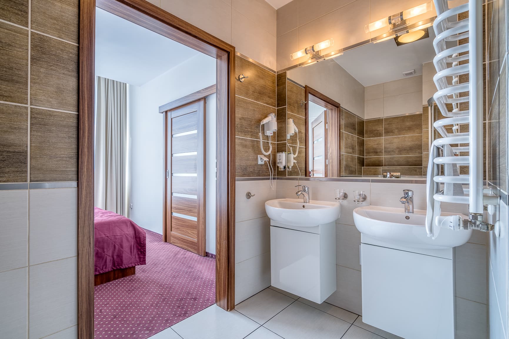 Łazienka z dwiema umywalkami w Hotelu Stork