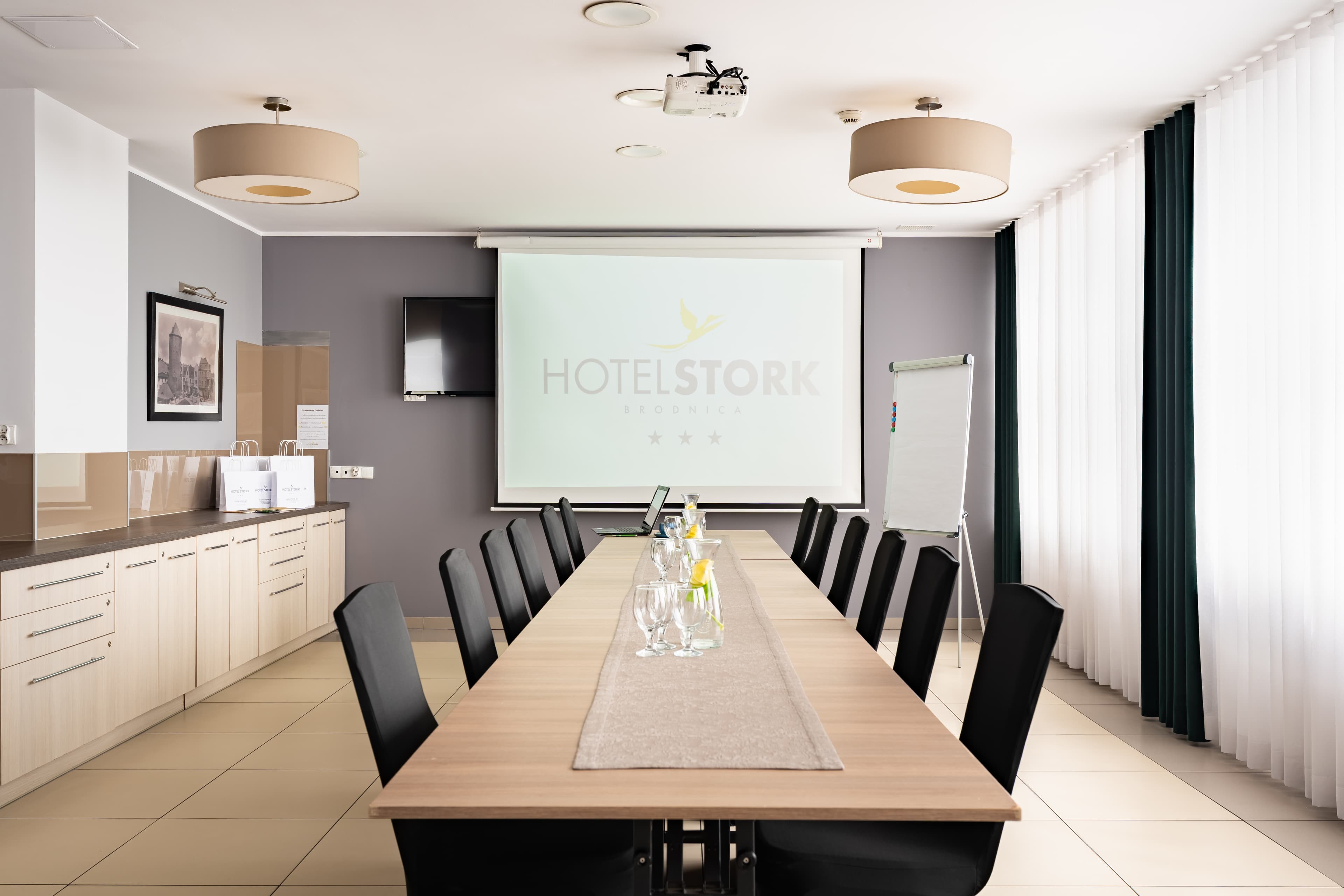 Sala konferencyjna z długim stołem i ekranem